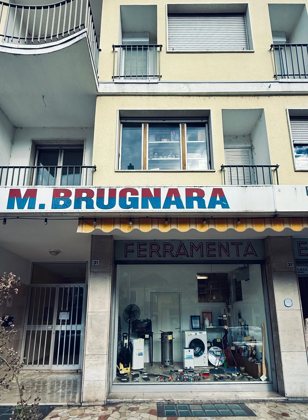 A hardware shop in Merano with a hand-painted sign reading M. Brugnara, Ferramenta.
