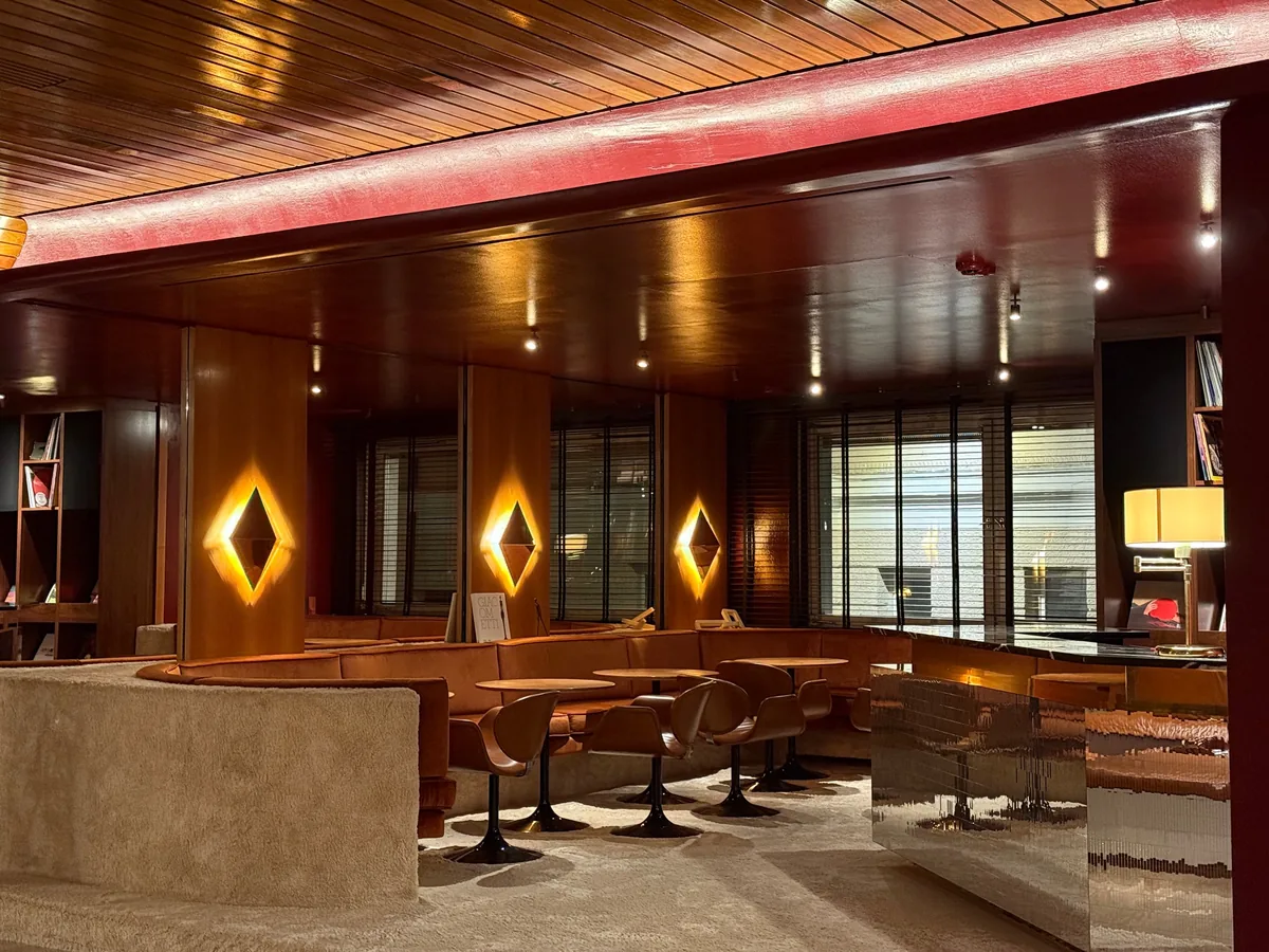 A 1960s hotel lounge with wood ceilings, tan leather banquettes and diamond-shaped wall lights.